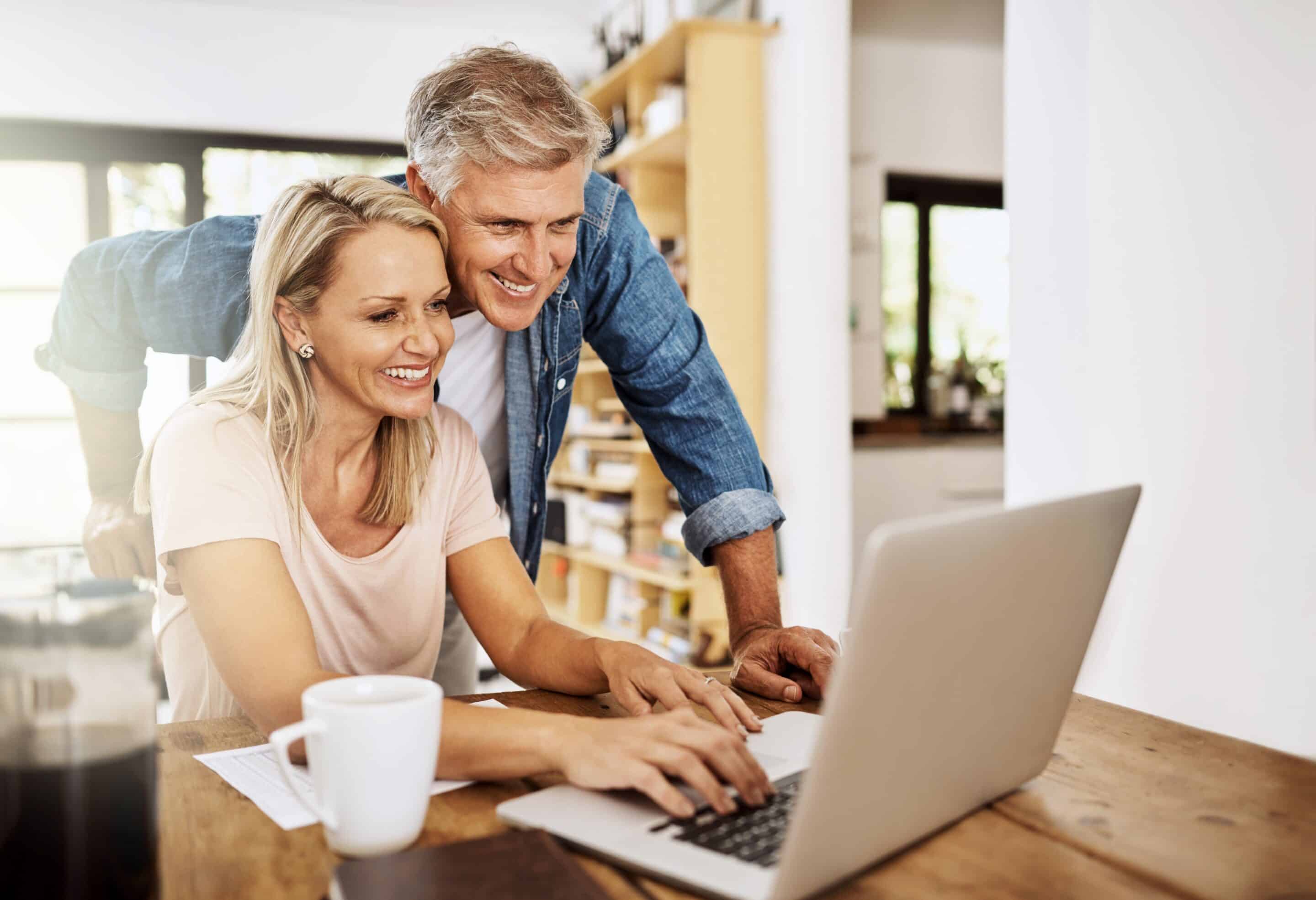 smiling couple donating appreciated stock to charity on a laptop