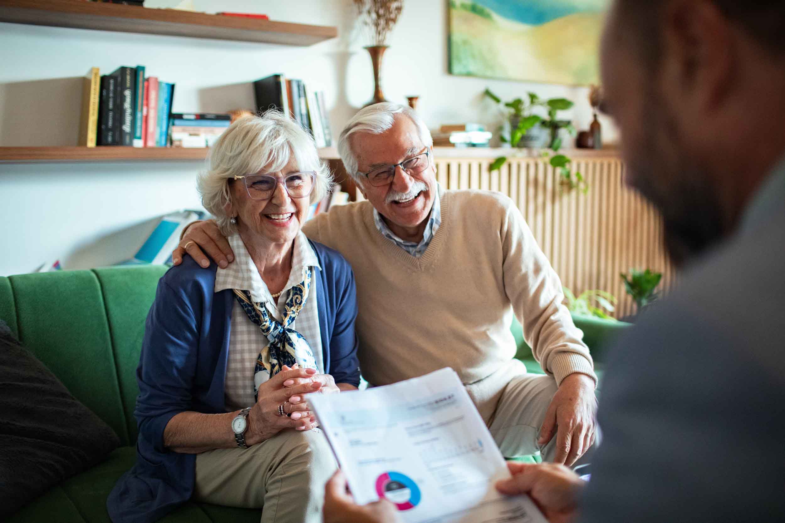 Senior couple having a serious conversation with financial advisor in living room
